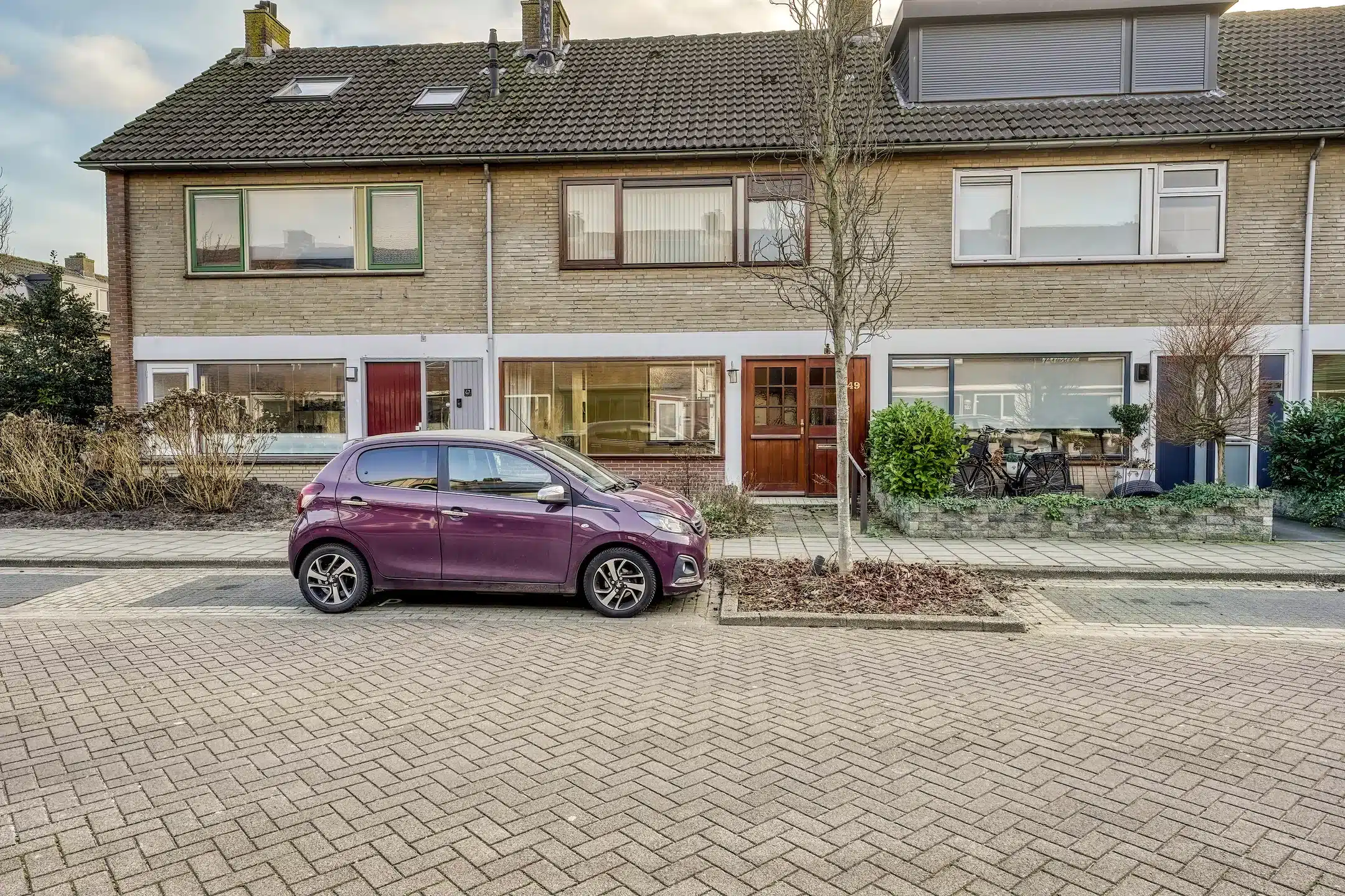 Paarse auto voor woning rijtjes huis