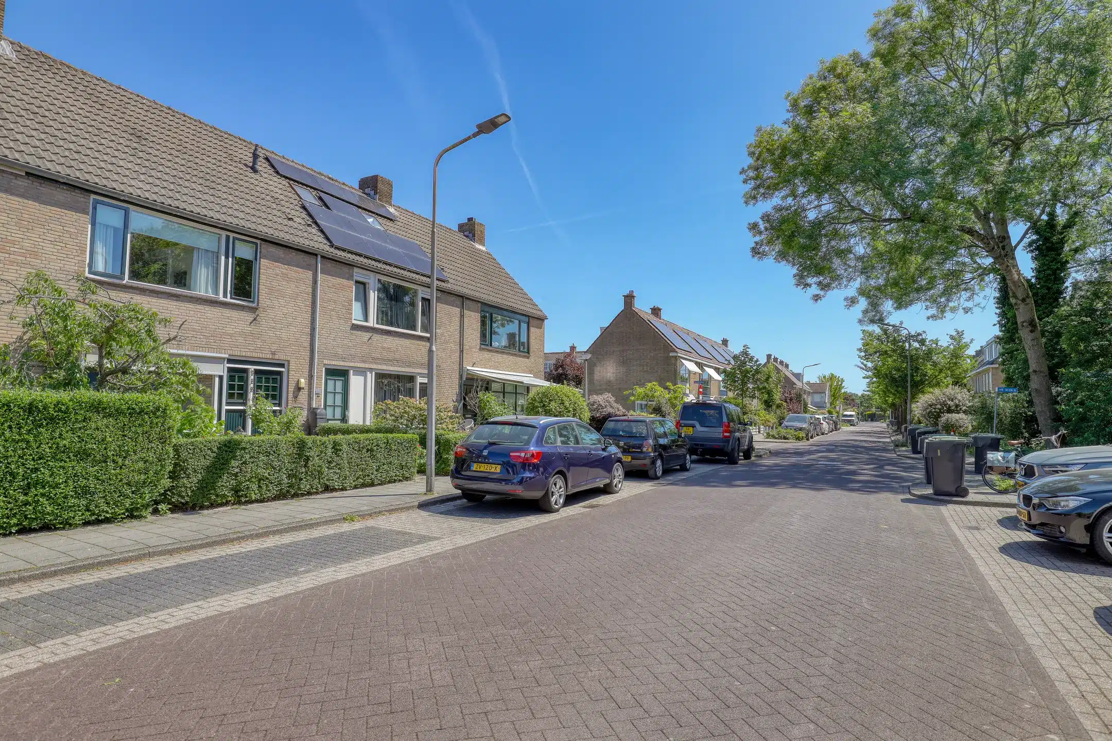 Rijtjes woning aan straat met auto's geparkeerd